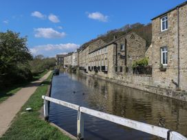 A canal with buildings alongside and a pathway at The Summerhouse in Kildwick