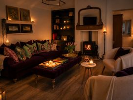A living room with a couch, table, and fireplace at The Summerhouse in Kildwick