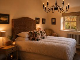 A bedroom with a bed, armchair and window at The Summerhouse in Kildwick