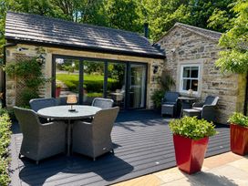 An outdoor seating area with a table and chairs at The Summerhouse Kildwick