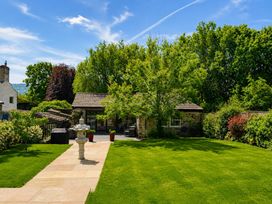 A garden with a pathway and trees at The Summerhouse in Kildwick