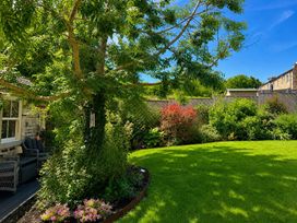 A garden with a tree and furniture at The Summerhouse in Kildwick