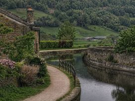 A building beside a waterway with a pathway at The Summerhouse in Kildwick