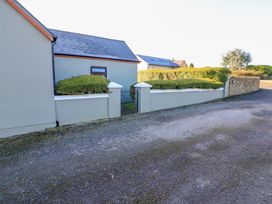 An outdoor area with a house, gate, and hedges at Thadg and Hannah’s in Miltown