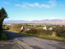 A scenic view of a road leading down to houses with mountains in the background at Thadg and Hannah’s in Miltown