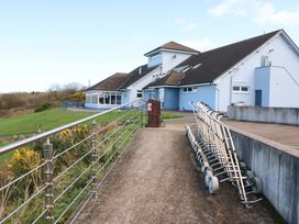 A building with a pathway and parked golf trolleys at Thadg and Hannah’s in Miltown