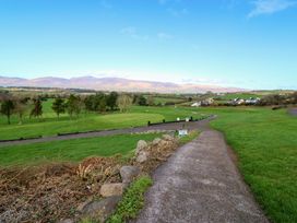 A path with grass and trees leading to mountains at Thadg and Hannah’s in Miltown