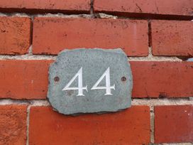 A slate plaque displaying the number 44 on a brick wall at 44 Love Lane Whitby