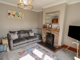A living room with a fireplace and sofa at 44 Love Lane, Whitby