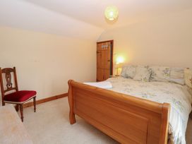 A bedroom with a bed and chair at Mabby in Caister-On-Sea