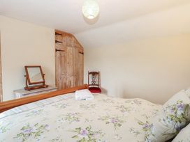 A bedroom with a bed and mirror at Mabby in Caister-On-Sea