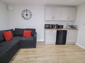 A living room with a sofa and kitchen area at Binevenagh Point Cabin