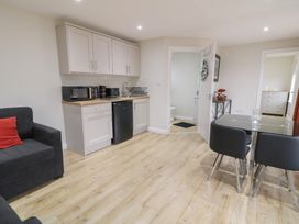 A kitchen with a refrigerator, microwave, and dining table at Binevenagh Point Cabin