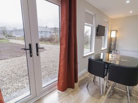 A dining area with glass table and chairs at Binevenagh Point Cabin