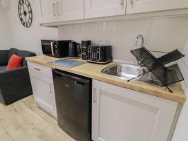 A kitchen with appliances including a microwave, kettle, and toaster at Binevenagh Point Cabin