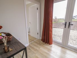 An entryway with a table and a window door at Binevenagh Point Cabin