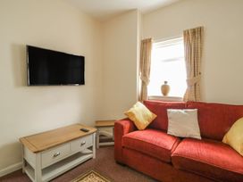 A living room with a television and sofa at No 8- Farmhouse Retreat in Keswick