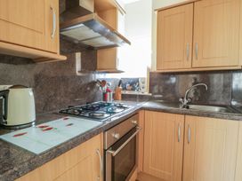 A kitchen with a gas stove and sink at No 8- Farmhouse Retreat, Keswick
