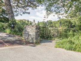 A stone wall and gate by a green area at No 8- Farmhouse Retreat in Keswick