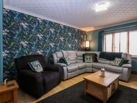 A living room with a sectional sofa and coffee table at 36 Cae Rhos in Holyhead