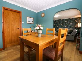 A dining room with a table and chairs at 36 Cae Rhos in Holyhead