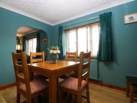 A dining room with a wooden table and chairs at 36 Cae Rhos in Holyhead
