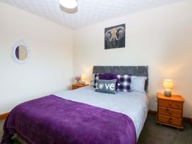 A bedroom with a bed and bedside tables at 36 Cae Rhos Holyhead