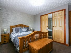 A bedroom with a bed and bedside tables at 36 Cae Rhos, Holyhead