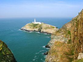 A lighthouse on an island surrounded by ocean at 36 Cae Rhos Holyhead