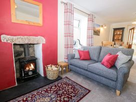A living room with a fireplace and sofa at Yewbarrow in Seascale