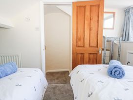 A bedroom with two beds and a door at Yewbarrow in Seascale