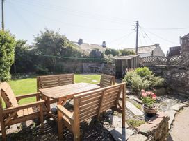 A garden with a wooden table and chairs at Yewbarrow Seascale