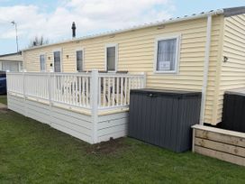 An outdoor area with a caravan and deck at Chappie's Caravan in Rhyl