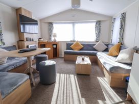 A living room with a sofa and coffee table at Chappie's Caravan in Rhyl