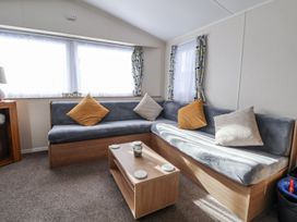 A living room with a sofa and coffee table at Chappie's Caravan Rhyl