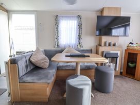 A living room with a sofa and table at Chappie's Caravan in Rhyl