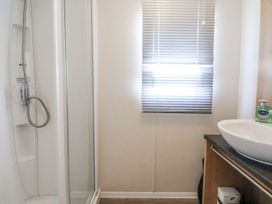 A bathroom with a shower and sink at Chappie's Caravan in Rhyl