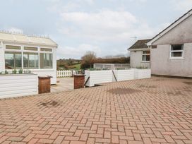 A garden with a conservatory and paved area at The Bungalow in St. Austell
