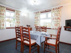 A dining room with a table and chairs at The Bungalow in St. Austell