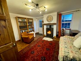 A living room with a bookshelf and fireplace at Penpegws near Aberystwyth