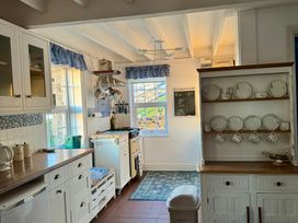 A kitchen with stove, sink, and dish rack at Penpegws near Aberystwyth