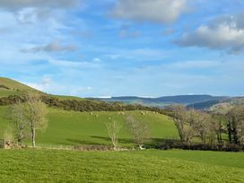A view of hills with green grass and trees at Penpegws near Aberystwyth