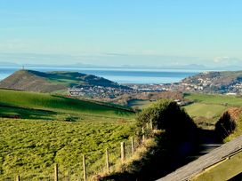 A landscape view of hills and a town by the sea at Penpegws near Aberystwyth