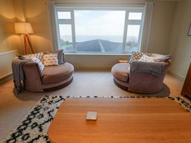 A living room with two sofas and a table at Cliff Cottage