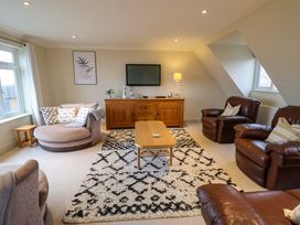 A living room with a sofa and chairs at Cliff Cottage