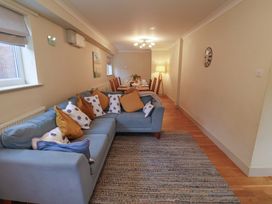 A living room with a sofa and dining area at Cliff Cottage