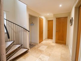 A hallway with a staircase and multiple doors at Cliff Cottage