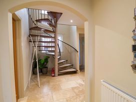 A hallway with a spiral staircase and a plant at Cliff Cottage