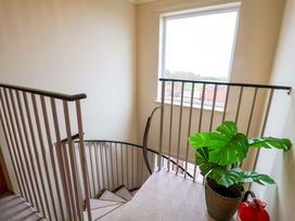 A staircase with a plant and fire extinguisher at Cliff Cottage