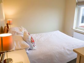A bedroom with a bed and bedside table at Cliff Cottage